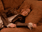 a woman laying on a couch with her eyes closed