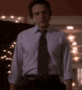 a man in a white shirt and tie is standing in a room