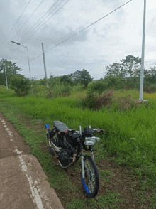 a black motorcycle is parked on the side of a dirt road