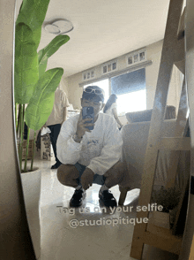 a man taking a selfie in front of a mirror with the caption tag us on your selfie @studiopticque