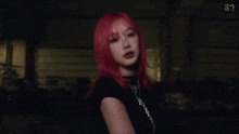 a woman with red hair is wearing a black shirt and a necklace