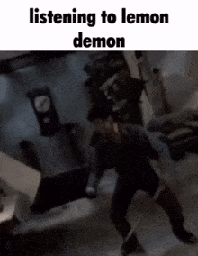 a man is standing in a dark room with the words listening to lemon demon written above him