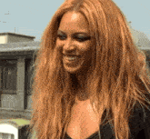 a woman with long blonde hair is smiling and wearing a black shirt