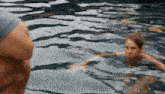 a man and a woman are swimming in a pool together .