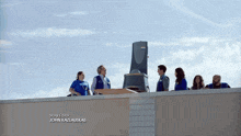 a group of people standing on top of a building with the story editor john kaziauskas