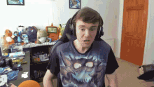 a man wearing headphones and a blue shirt with a dragon on it