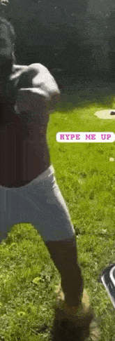 a shirtless man in white underwear is standing in the grass in a park .