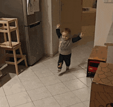 a little boy wearing a shirt that says the lion king stands on a tiled floor