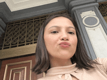a woman making a funny face in front of a door