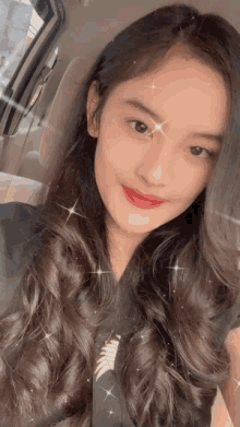 a girl with long hair and red lipstick is taking a selfie