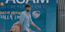 a man standing in front of a sign that says " sevilla "