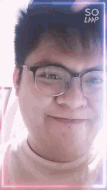 a man wearing glasses is smiling in front of a so loop advertisement