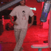 a person wearing a white t-shirt with a picture of a girl on it is standing in front of a microphone .