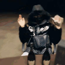 a person wearing a fur coat is sitting in a chair holding a bag of money .