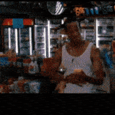 a man in a white tank top is standing in a store with a sign that says 666 on it
