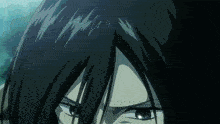 a close up of a person 's face with dark hair and blue eyes