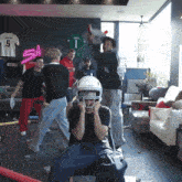 a man wearing a football helmet is surrounded by people