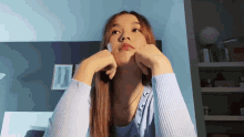 a woman in a blue sweater looks up at the sky