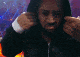 a man wearing a black jacket with a hood is taking a picture of himself