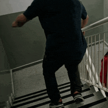 a man walking down a set of stairs with a white railing