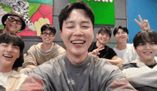 a group of young men are posing for a picture and one of them has his tongue out