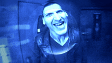 a man in a black shirt is laughing in a blue light