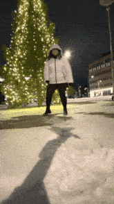 a person standing in front of a christmas tree