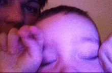 a close up of a person holding a baby 's head