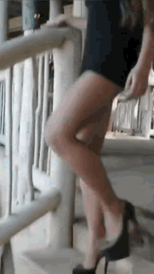 a woman in high heels is walking down stairs .
