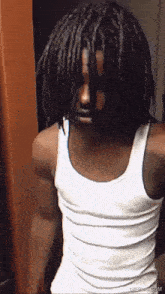 a man with dreadlocks is wearing a white tank top ..