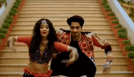 a man and woman are dancing on a set of stairs .