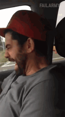 a man wearing a red hat is sitting in a car with failarmy written on the bottom right