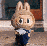a stuffed animal wearing a bunny costume and overalls