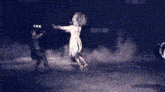 a woman in a white dress is dancing with a man