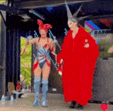a woman in a bunny costume and a woman in a red coat are standing next to each other on a stage .