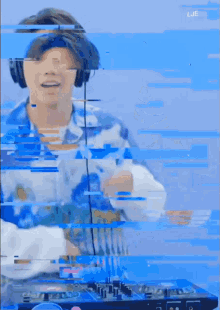 a man wearing headphones and a headband is playing a dj mixer .