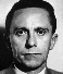a black and white photo of a man wearing a suit and tie .