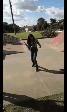 a girl is riding a skateboard in a skate park with graffiti on a wall