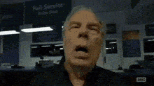 a man is yawning in front of a sign that says " full service "