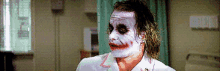 a man with white paint on his face is wearing a white shirt .