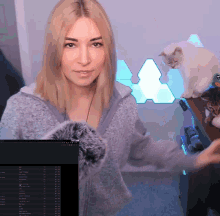 a woman is standing in front of a computer screen that says ' a ' on it