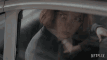 a woman in a car with a netflix logo on the bottom right