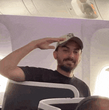 a man wearing a hat with the letter s on it salutes on an airplane