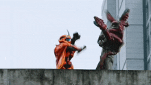 a couple of robots are fighting each other on a concrete wall .