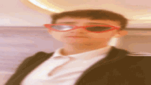 a blurry photo of a young man wearing red sunglasses