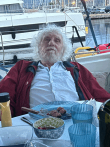 a man sits at a table with a plate of food in front of a boat that says ball on it