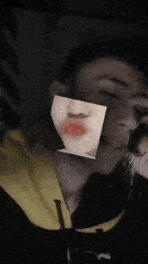 a man with a picture of a woman 's face covering his face
