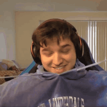 a young man wearing headphones and a blue shirt that says ' thunderbolts ' on it