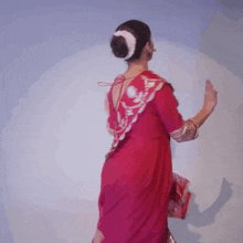 a woman in a red dress is holding an arrow