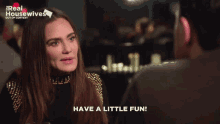 a woman says have a little fun in front of a real housewives sign
